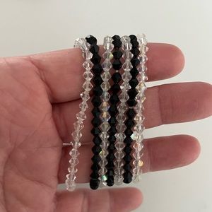 7 shiny elastic bracelets.  3 black beaded bracelets, 4 clear beaded bracelets.